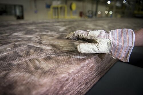Dieses Bild zeigt eine ungeschnittene Dämmrolle bei der Herstellung von Mineralwolle.